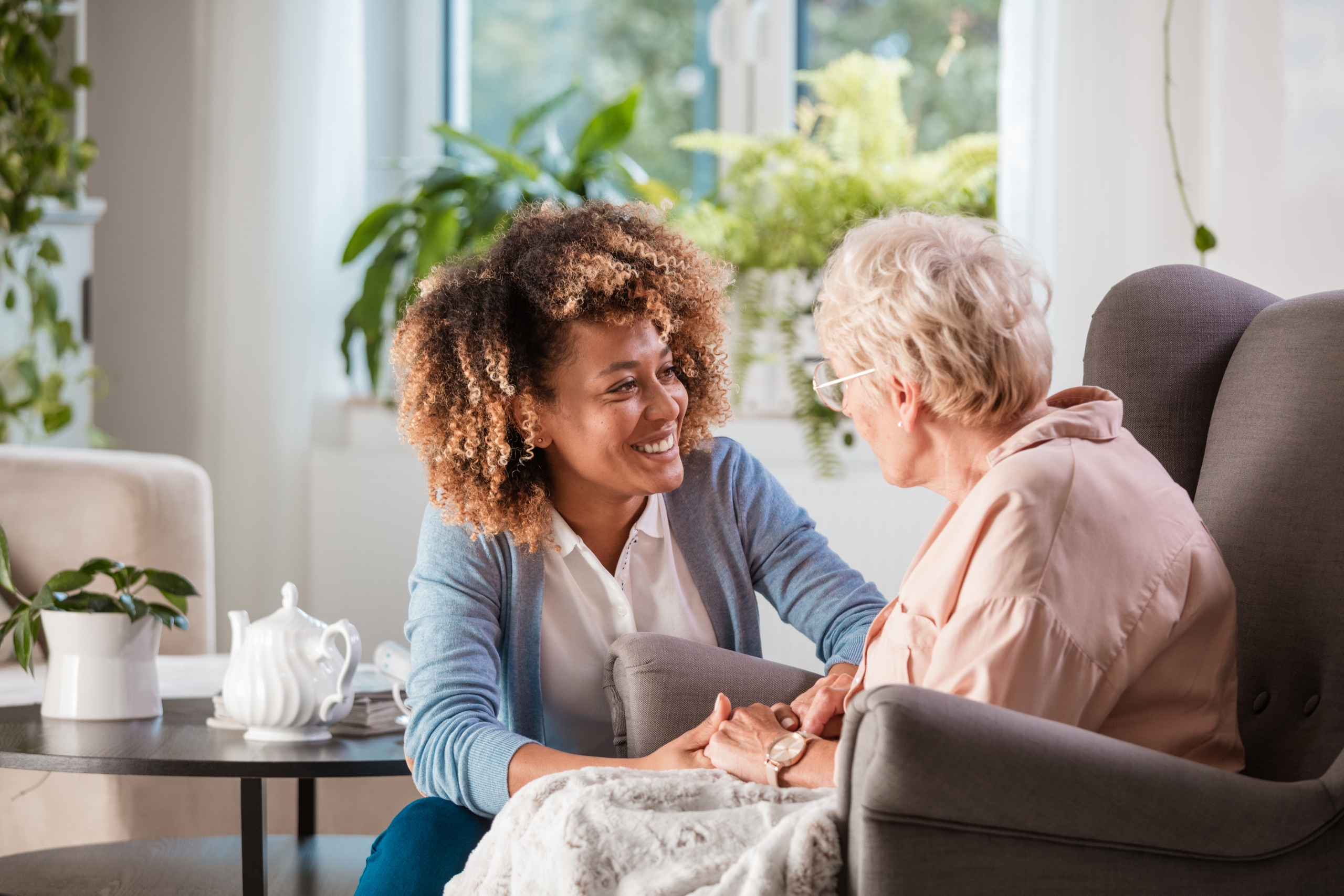 at home caregiver laughing with senior woman