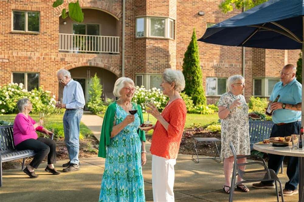seniors having drinks and conversing at the outdoor campus of HCK