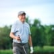 senior man smiling while playing golf