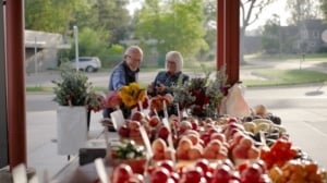 A senior man and senior woman looking at flowers found at the Fresh on Q in TexasTownship