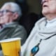Close up of elderly couple at the movie theater holding popcorn cup.